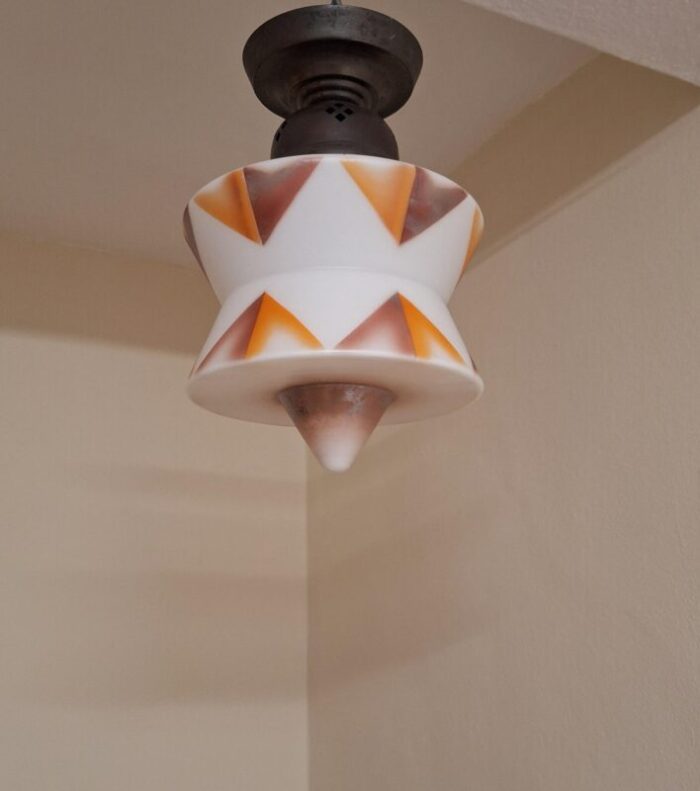 art deco german ceiling lamp with white glass shade with an orange brown spray decorative motif on an original brass mount 5563