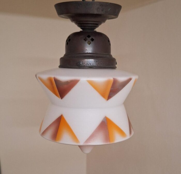 art deco german ceiling lamp with white glass shade with an orange brown spray decorative motif on an original brass mount 6995